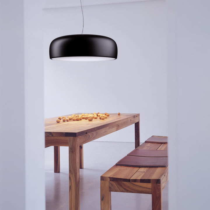 The Smithfield Pro pendant luminaire from Flos in matt black above a natural wood dining table