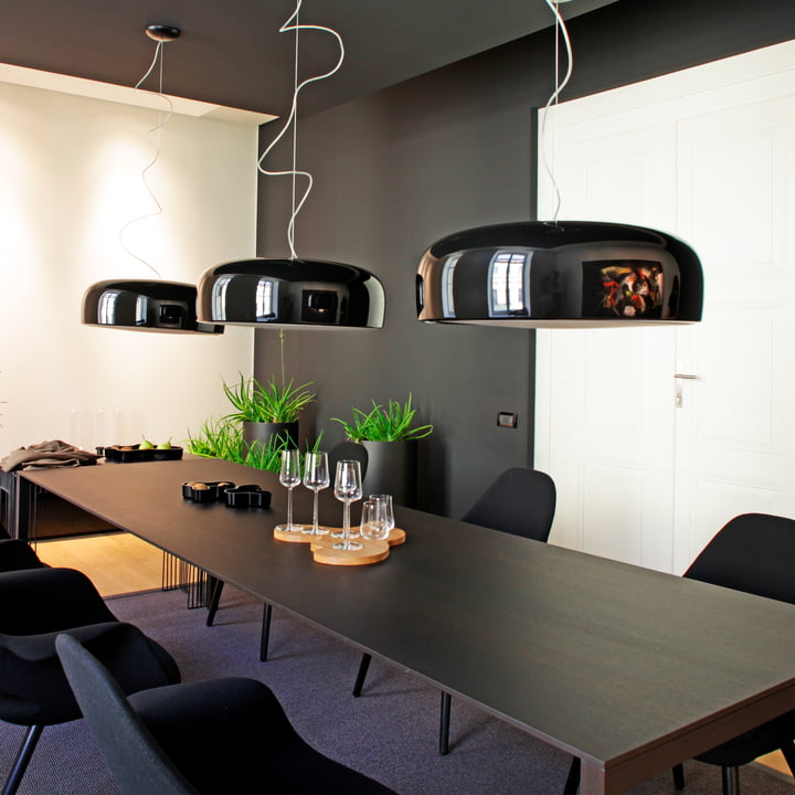 The Smithfield Pro pendant lamp from Flos in black above a long, black dining table