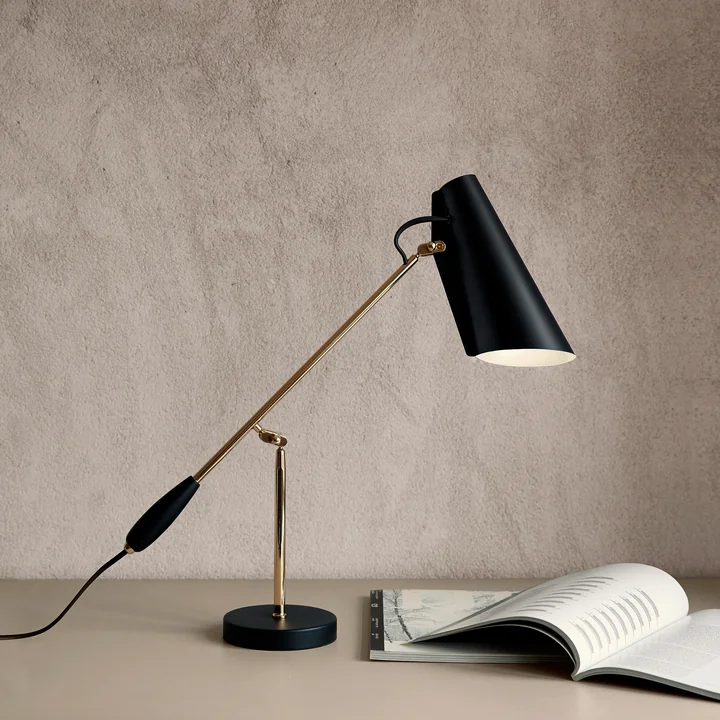 The Birdy Table lamp from Northern next to a book