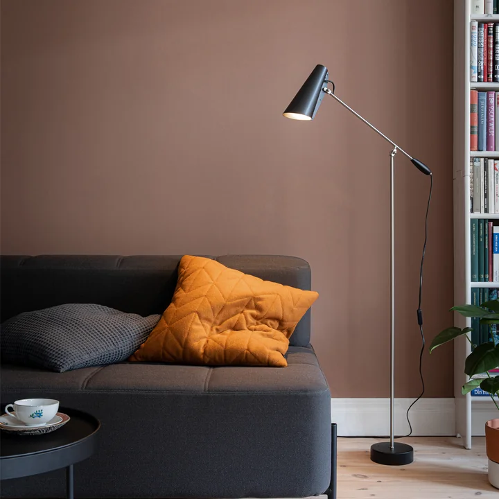 The black Birdy Floor lamp from Northern in the living area next to a dark sofa