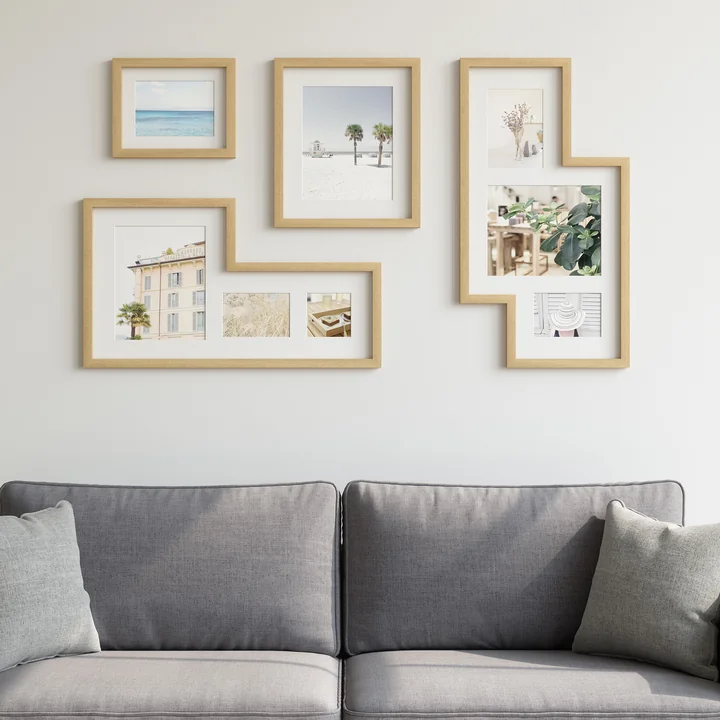The Mingle Gallery picture frame from Umbra in nature above a grey sofa