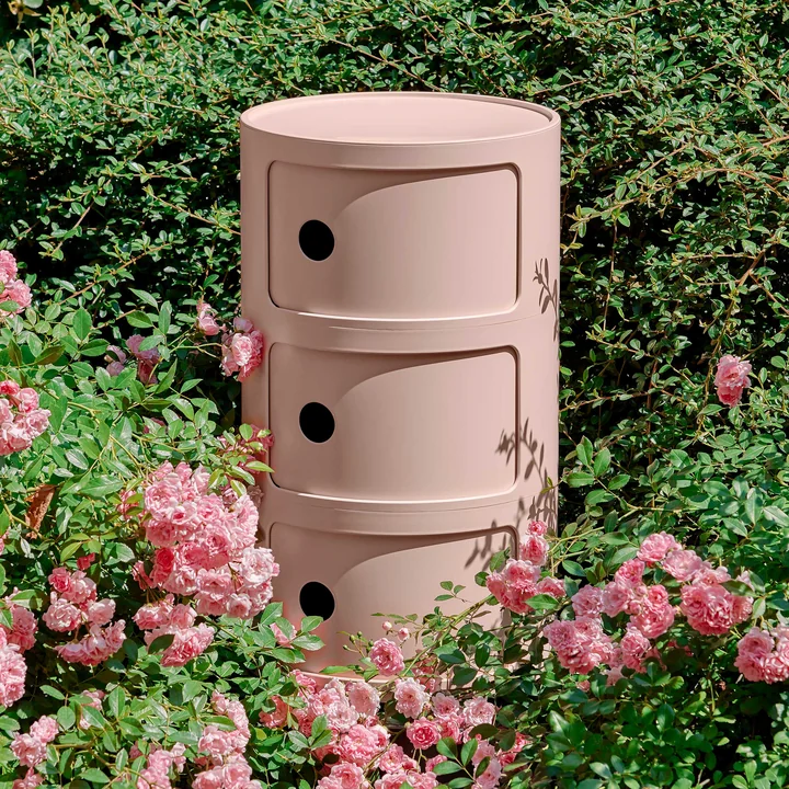 The Componibili Bio 5970 from Kartell in pink between rose bushes