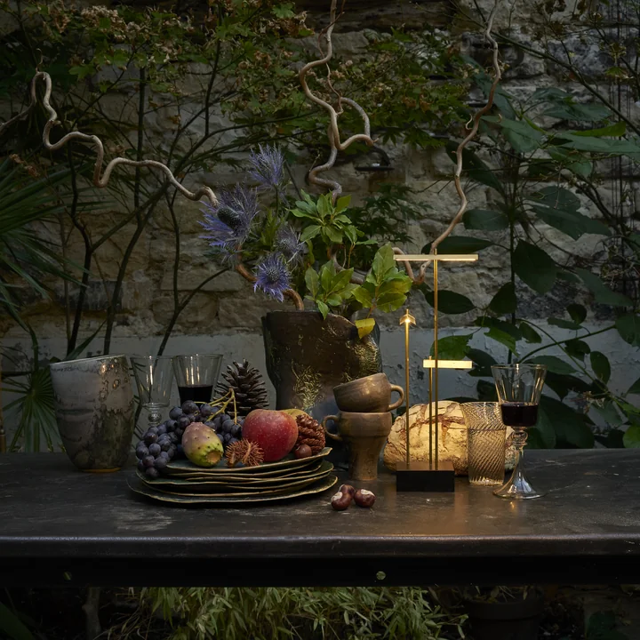 The Knokke rechargeable LED table lamp from DCW on a dining table with wild decoration