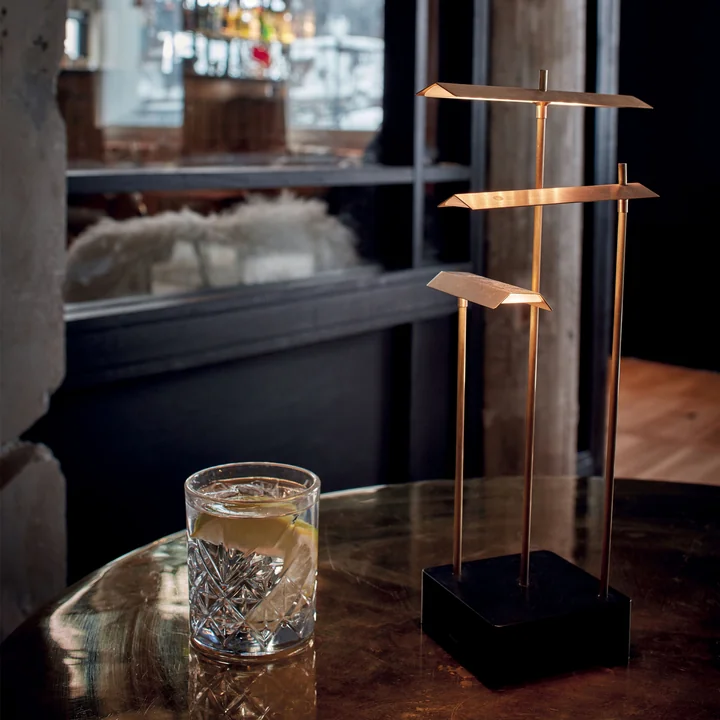 The Knokke rechargeable LED table lamp from DCW on a table in a restaurant