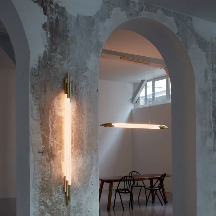 The Org LED wall lamp and pendant light from DCW in a rough room with high ceilings.