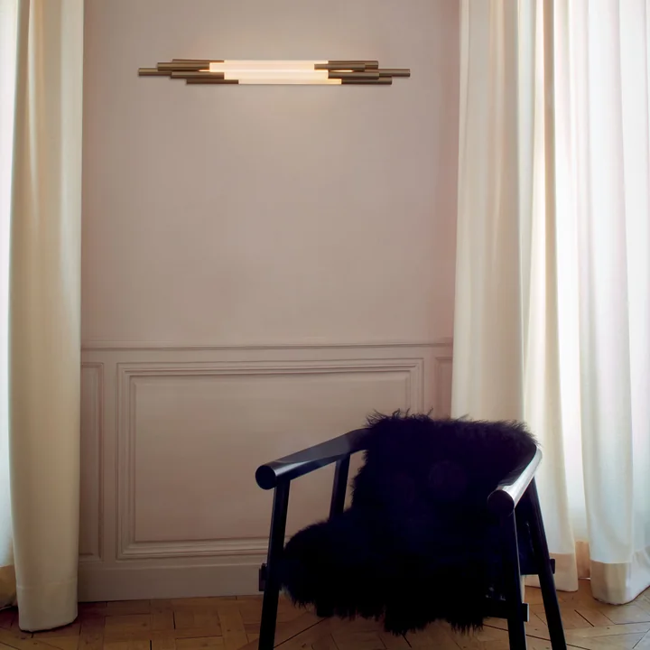 The Org LED wall lamp by DCW on the living room wall above an armchair