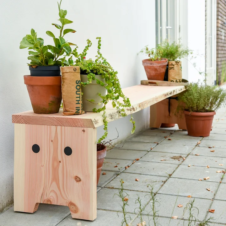 The Forestry bench from Weltevree outside with many plants
