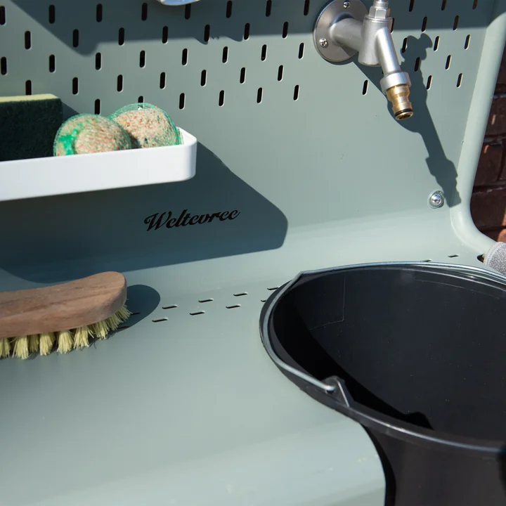 The bucket hangs on the Waterworks storage table for faucet from Weltevree