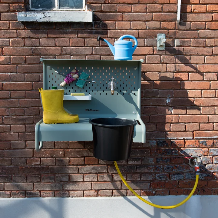 The Waterworks storage table from Weltevree with rubber boots, chalk and toys
