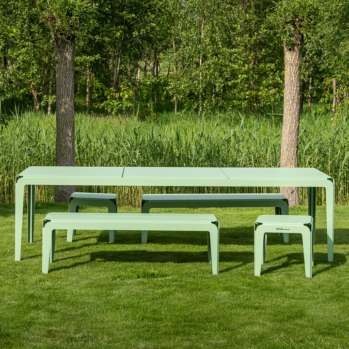The Bended Bench bench and the Bended table from Weltevree on a green meadow