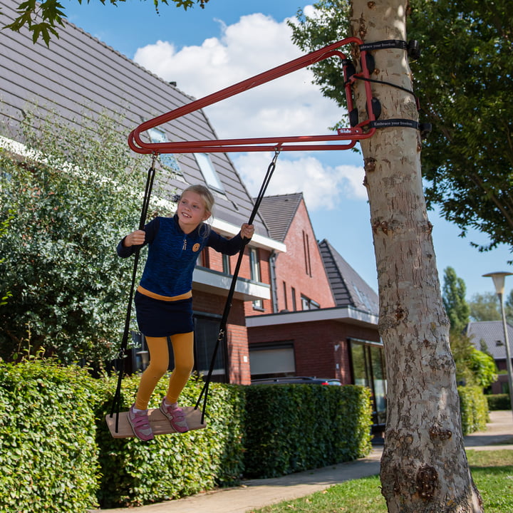 The Swing swing from Weltevree on a tree in a neighborhood of houses.