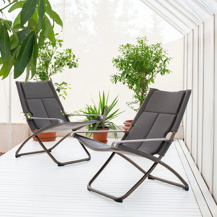 The Snooze recliner Cozy from Emu in a bright room with lots of plants.