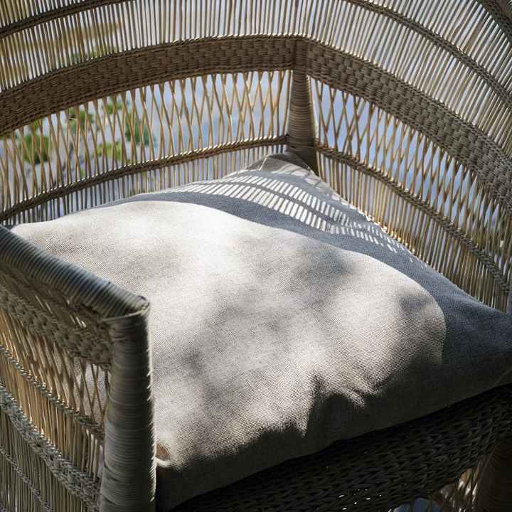 The Fine outdoor cushion from House Doctor in a woven outdoor chair