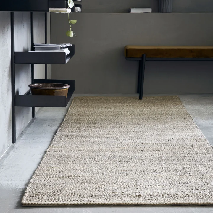 The natural Hempi carpet runner from House Doctor in front of a wall shelf