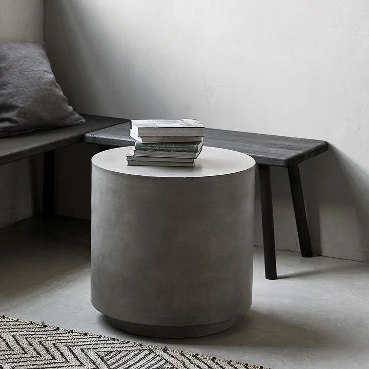 The Out concrete side table from House Doctor in front of a bench in the living room