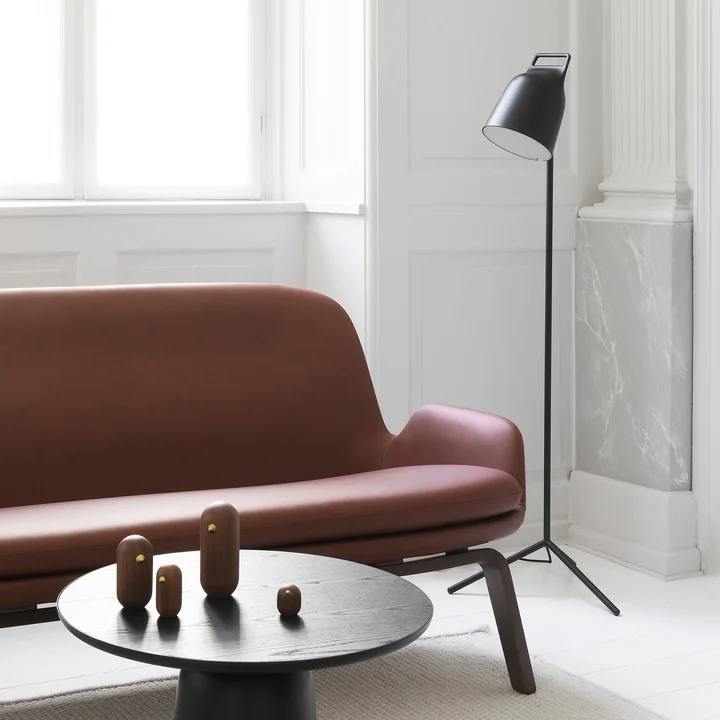 The Stage LED floor lamp from Normann Copenhagen next to a brown leather couch