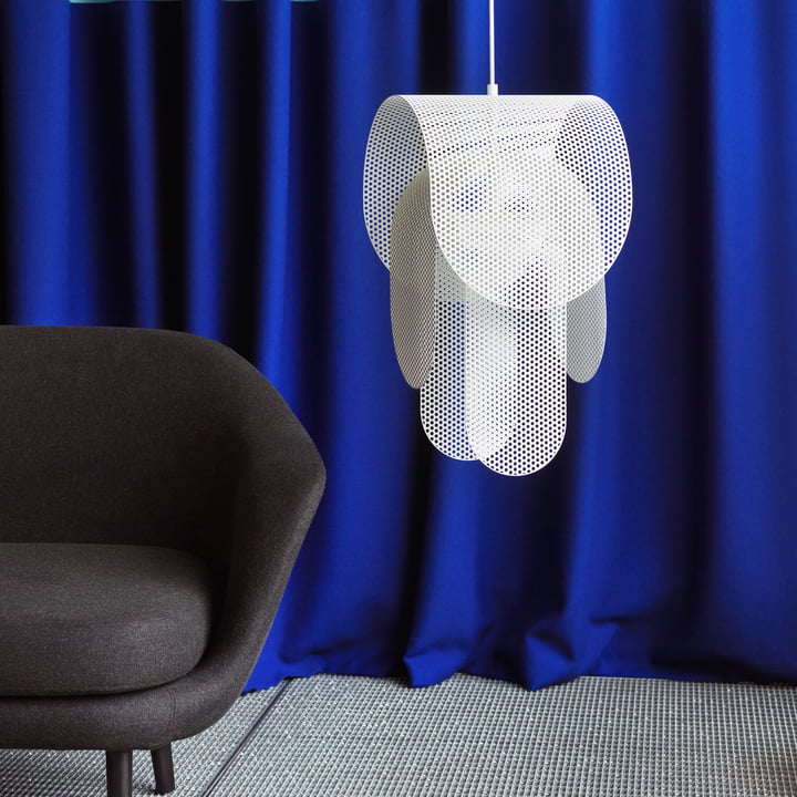 The Superpose pendant lamp from Normann Copenhagen next to a black armchair