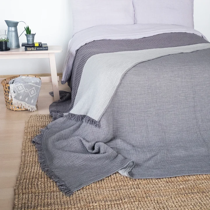The Cocoon blanket from the Collection nestles on the bed