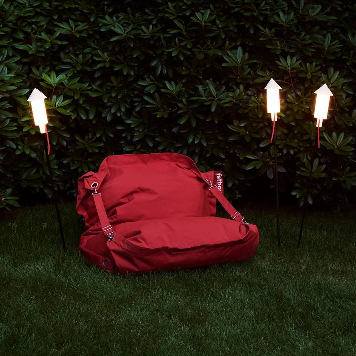 The Prêt a Racket solar light in the garden next to a sofa by Fatboy