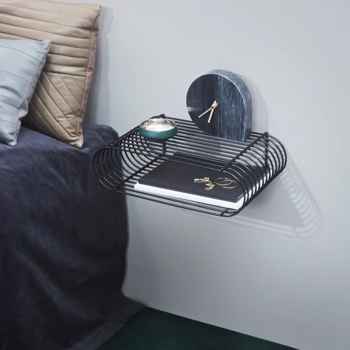 The Curva wall shelf from AYTM as a bedside cabinet next to the bed
