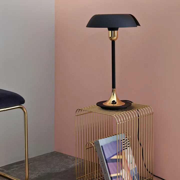 The Cycnus table lamp from AYTM on a golden side table