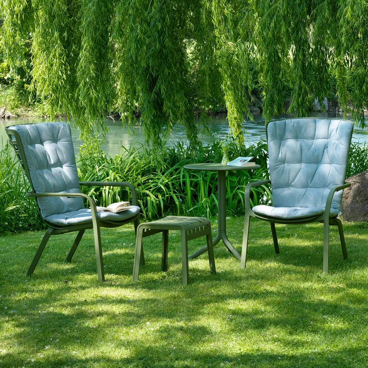 The green Folio armchairs and the Poggio stool in the garden