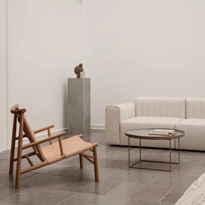 The Duke coffee table from Norr11 next to armchair and couch