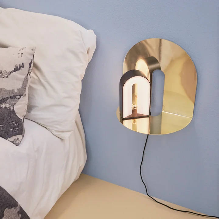 The Castellum wall shelf from AYTM as a bedside table next to the bed