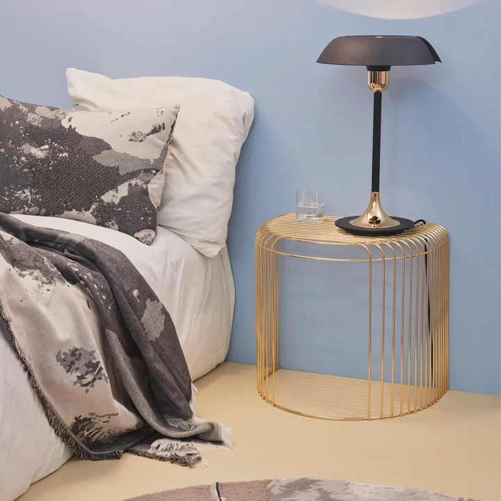 The Curva side table from AYTM as a bedside table next to the bed