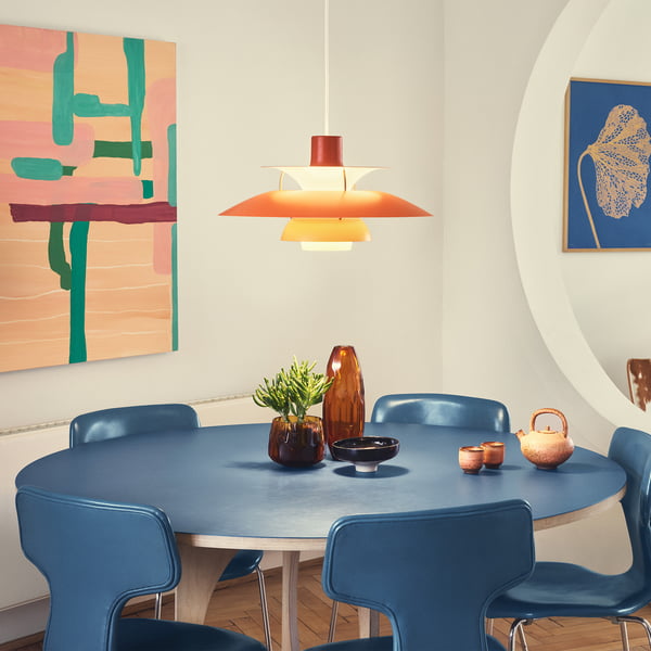 The PH 5 pendant light, hues of orange from Louis Poulsen above a dining room table