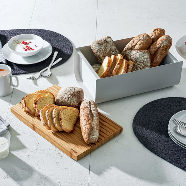 The Mattina bread box with cutting board by Alessi on the set breakfast table