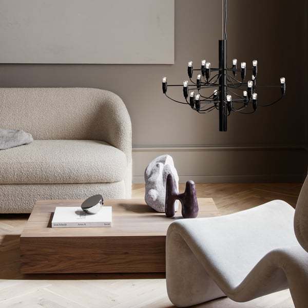 The chandelier 2097/18 from Flos in the living area next to a beige sofa and a low coffee table