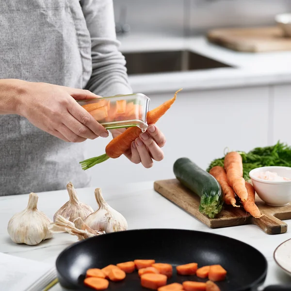 The PeelStore peeler with waste tray from Joseph Joseph ensures cleanliness when peeling.