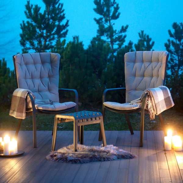 The Folio armchairs with the Poggio stool in the evening on the terrace